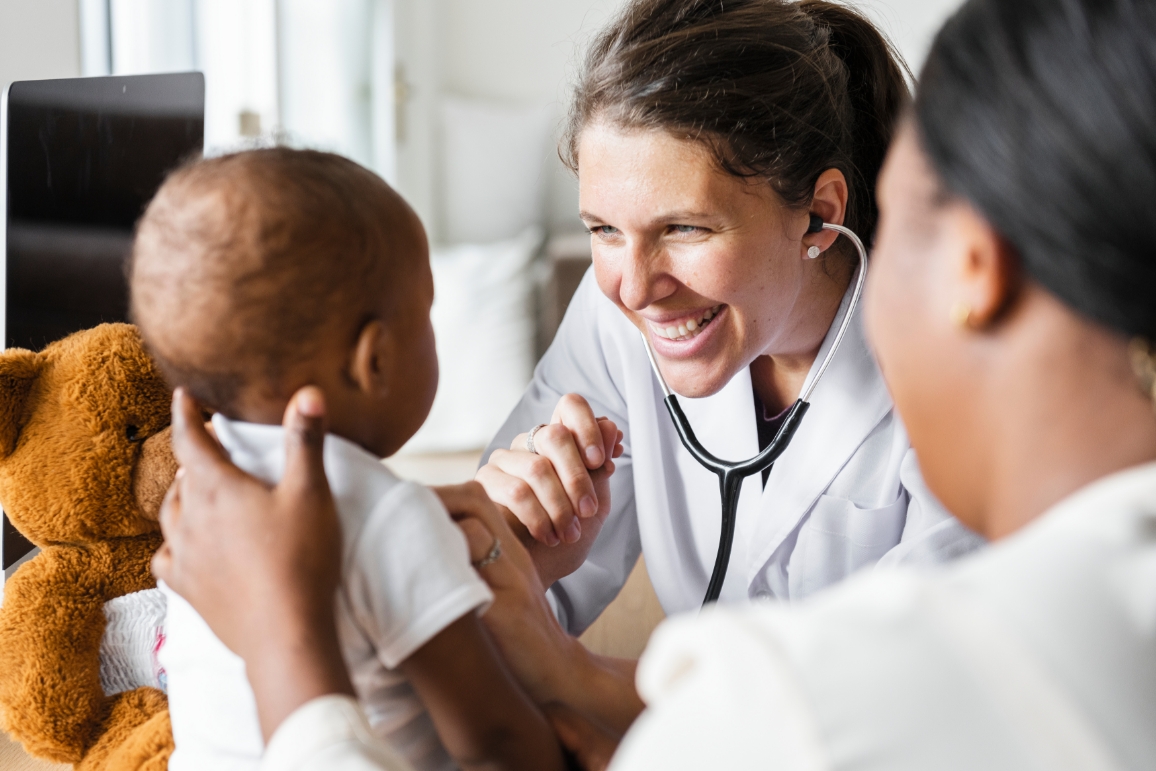 smiling doctor with a baby patient